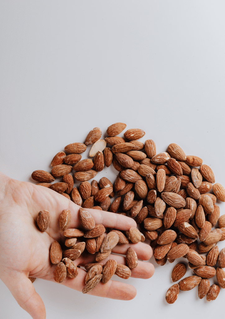 A picture of a hand full of almonds.