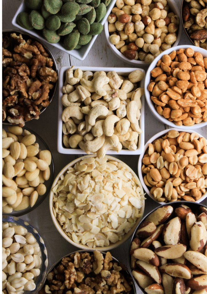A picture displaying several bowls contain variety of nuts in it.